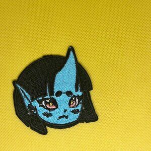 Cute embroidered patch featuring a blue alien character with big expressive eyes